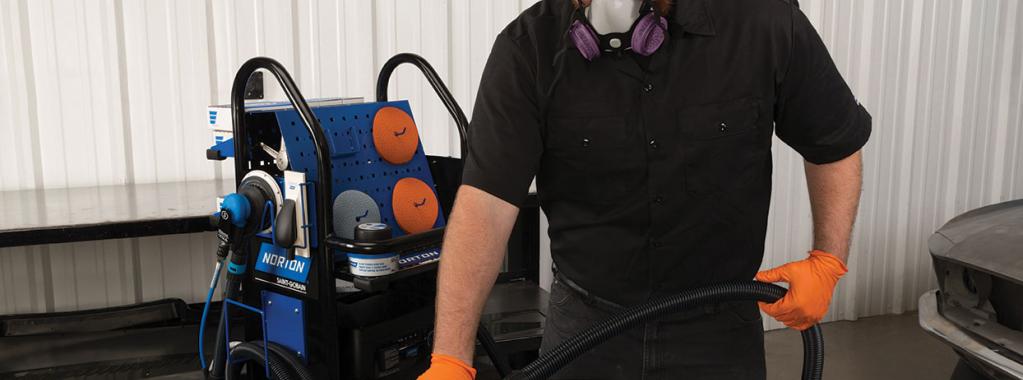 Man using the hand block on the VAC RACK to sand a car