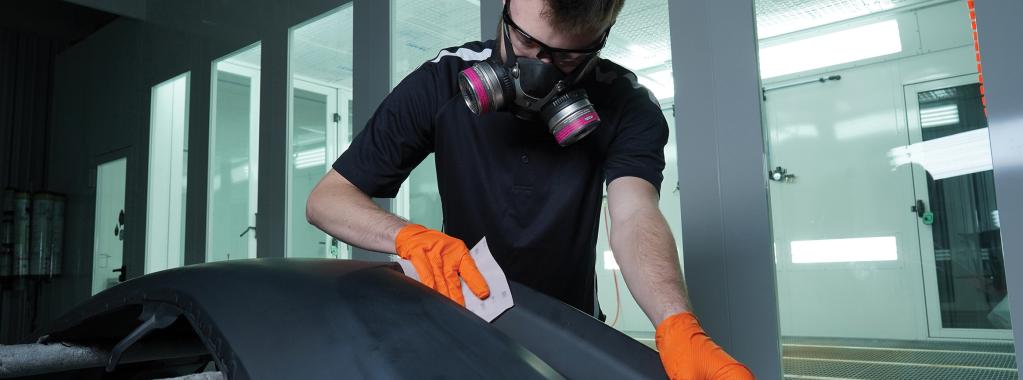 Man sanding a bumper with a Norton SuperFlexible Film sheet