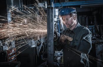 Man using a right angle grinder to grind workpiece