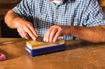 Man sharpening knife on Norton waterstone kit