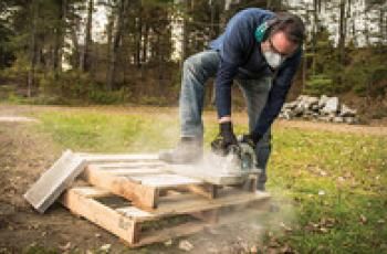 Man using a circular saw to cut patio stones
