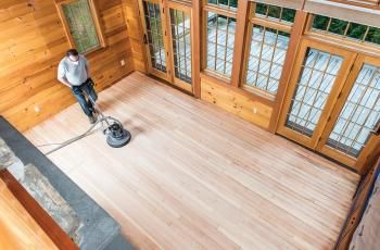 Man using a floor buffing machine on wood floors
