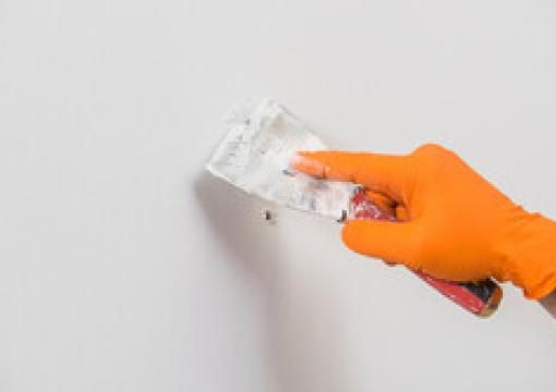Applying drywall compound over a nail pop