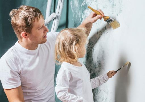 Man och dotter målar en vägg