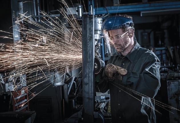 Man using a right angle grinder to grind workpiece