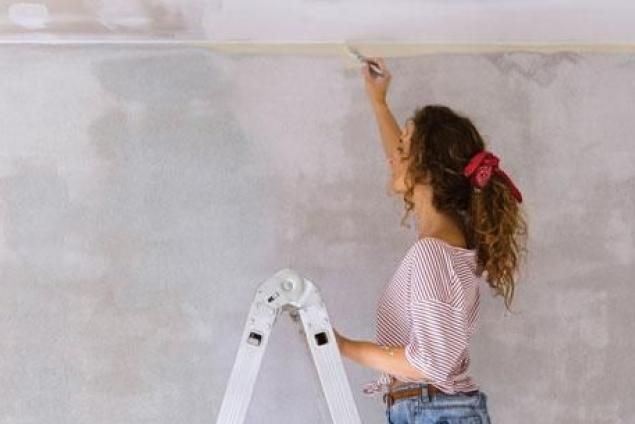 Woman working on a wall