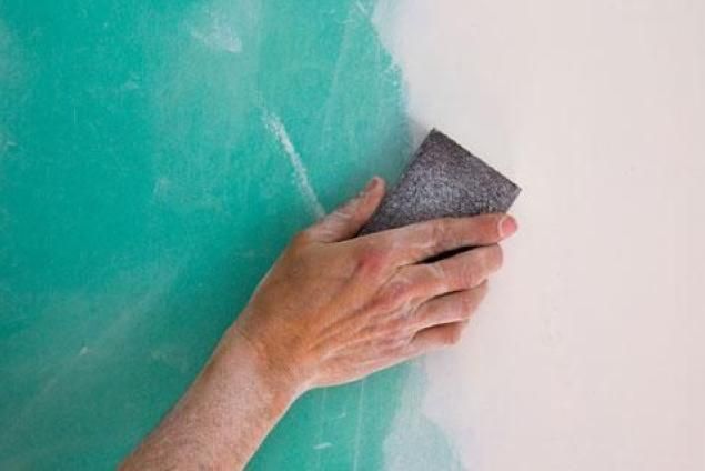 Hand sanding a wall