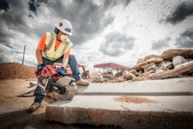 Construction worker using a gas saw to cut concrete