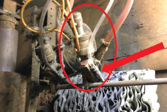 Liquid buffing compound is sprayed through nozzles and onto the buffing wheel