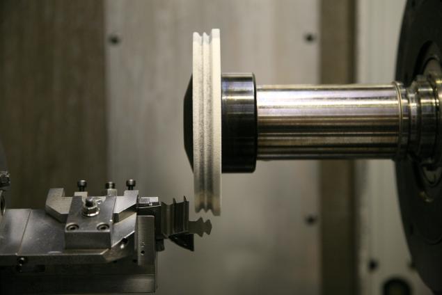 Uma máquina fazendo uma peça de metal em um torno.