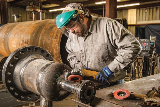 Operator grinding with a flap disc