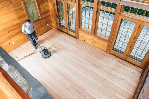 Man using a floor buffing machine on wood floors