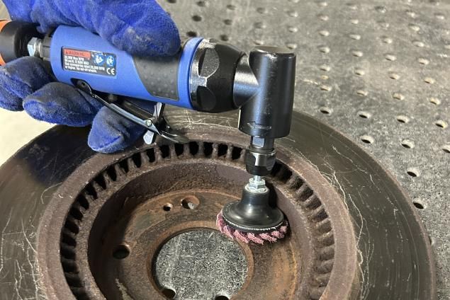 Operator using a Norton Vortex Rapid Prep mini flap disc to work on tight, confined part features