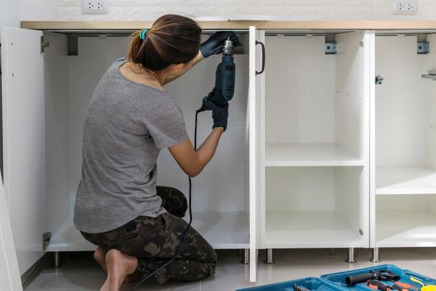Lady removing kitchen doors ready for painting