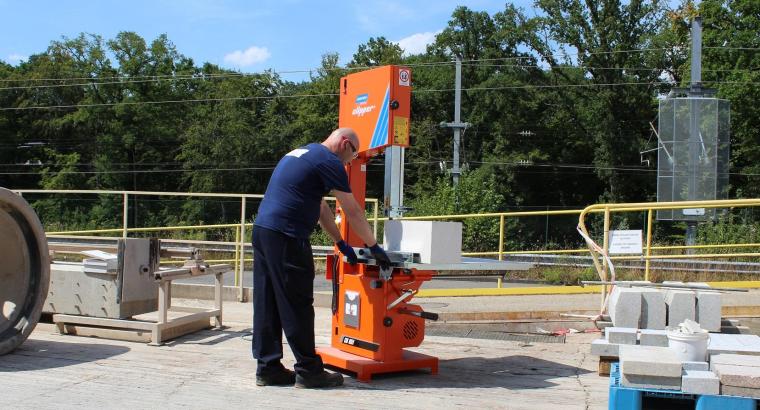 Norton Clipper CB511 band saw cutting lightweight construction blocks on a jobsite