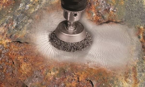 using wire brush to remove rust
