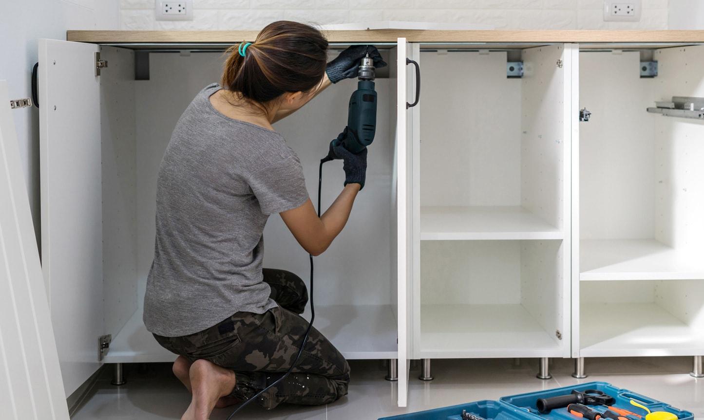 Lady removing kitchen doors ready for painting